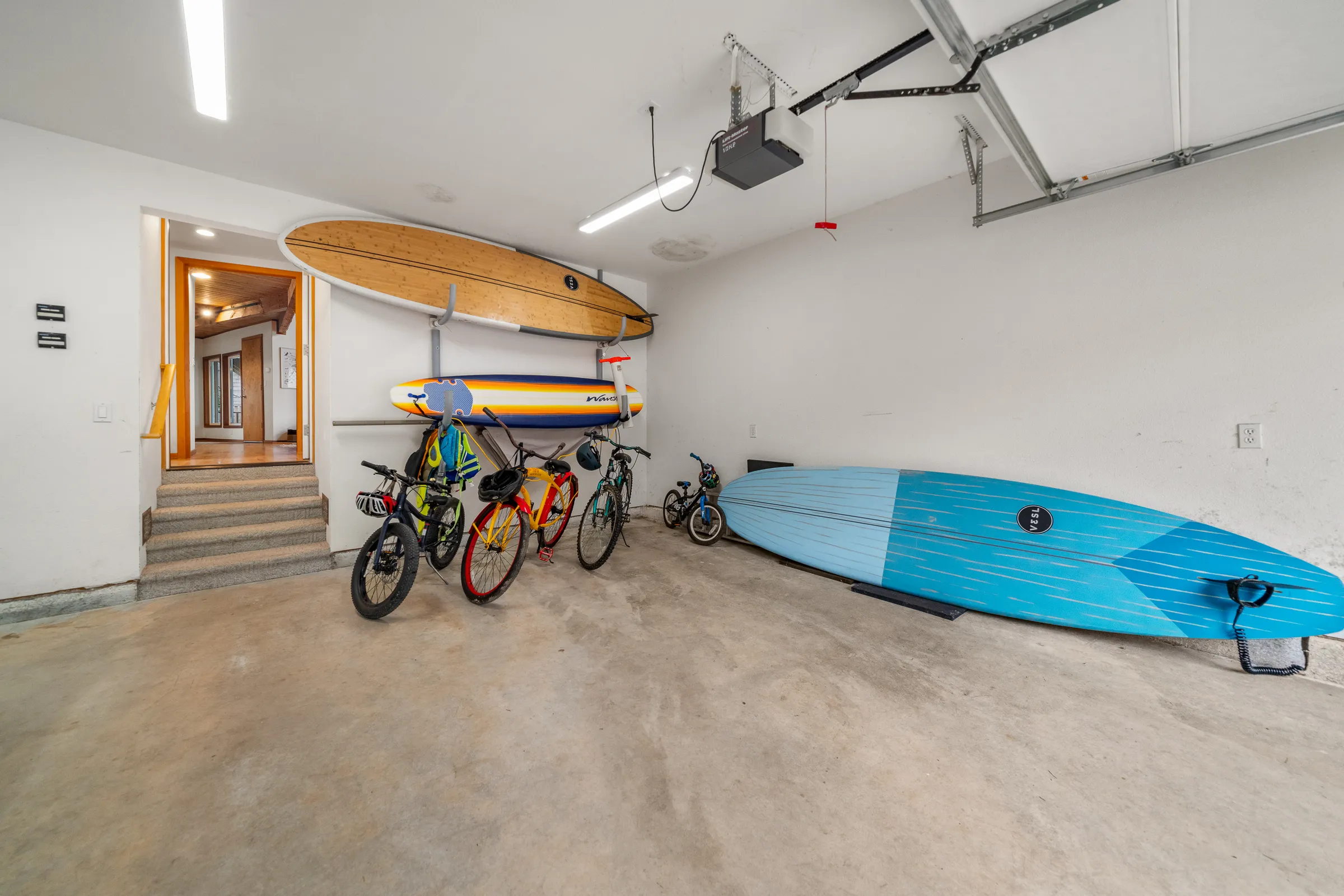 Bikes, surfboard, and paddle boards in the garage