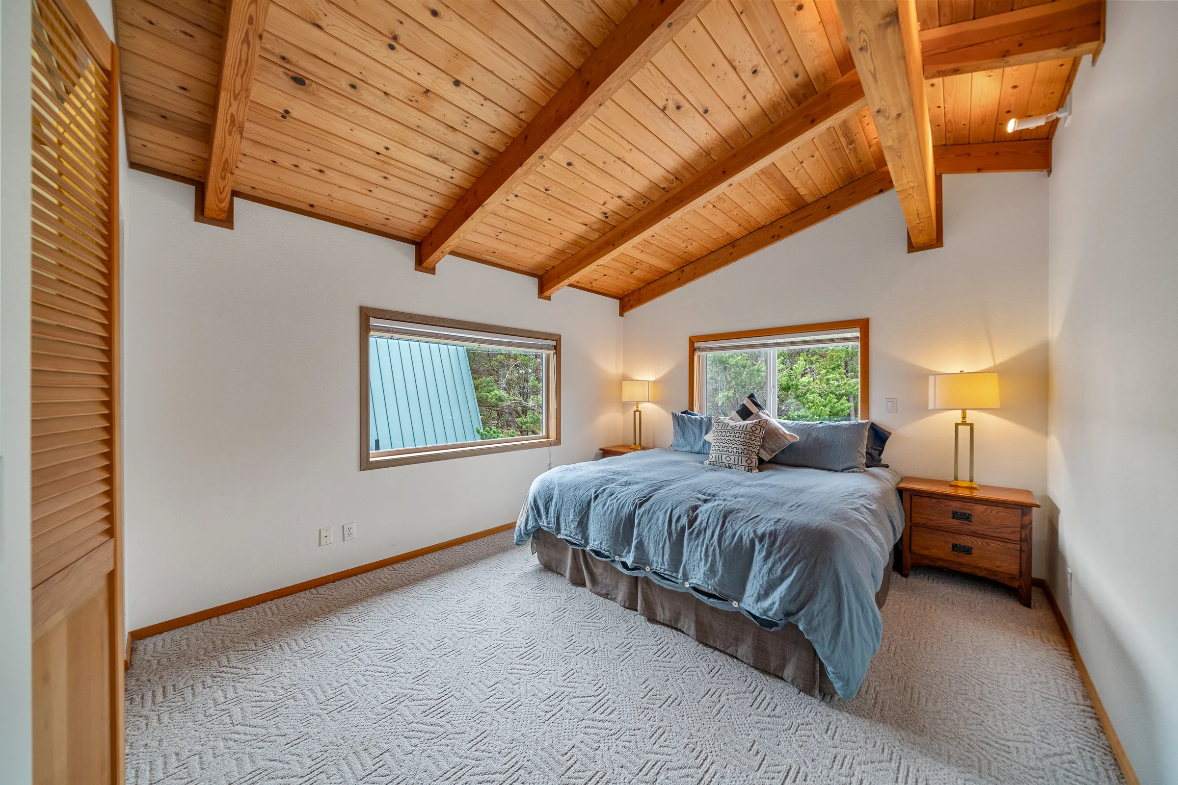 Master bedroom with blue duvet and exposed beams